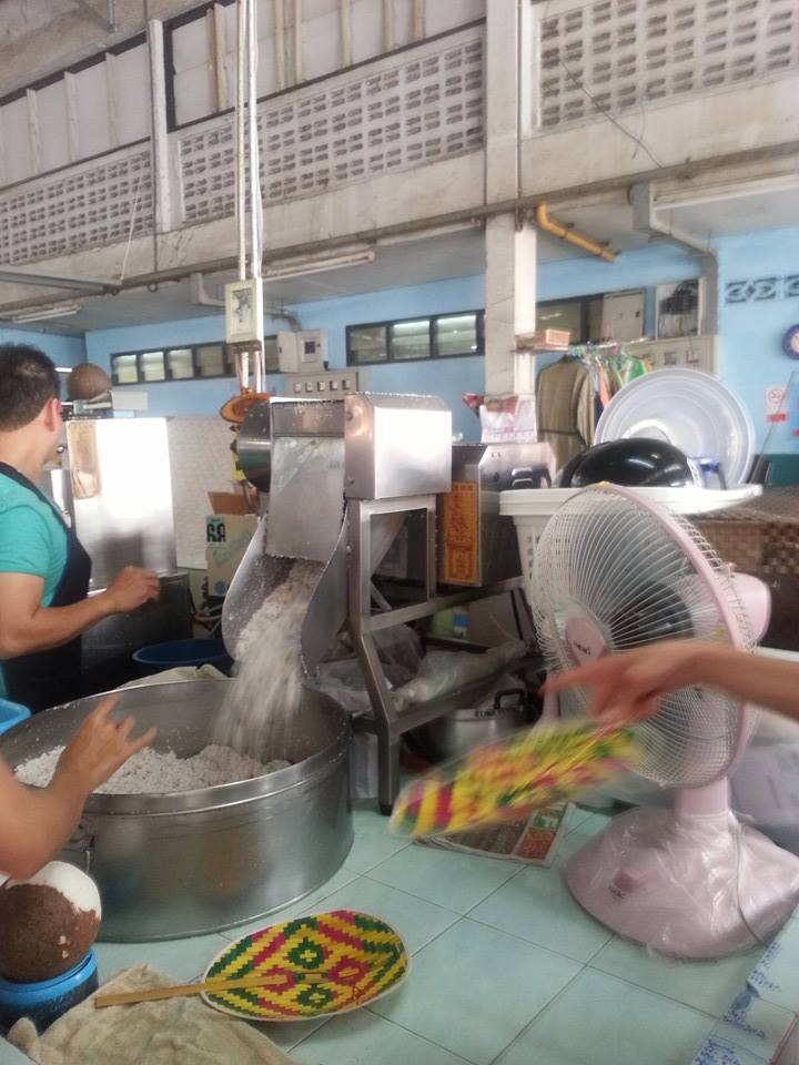 Coconut is shredded in machine and then vendor puts shreds into other machine to turn it into coconut paste. 