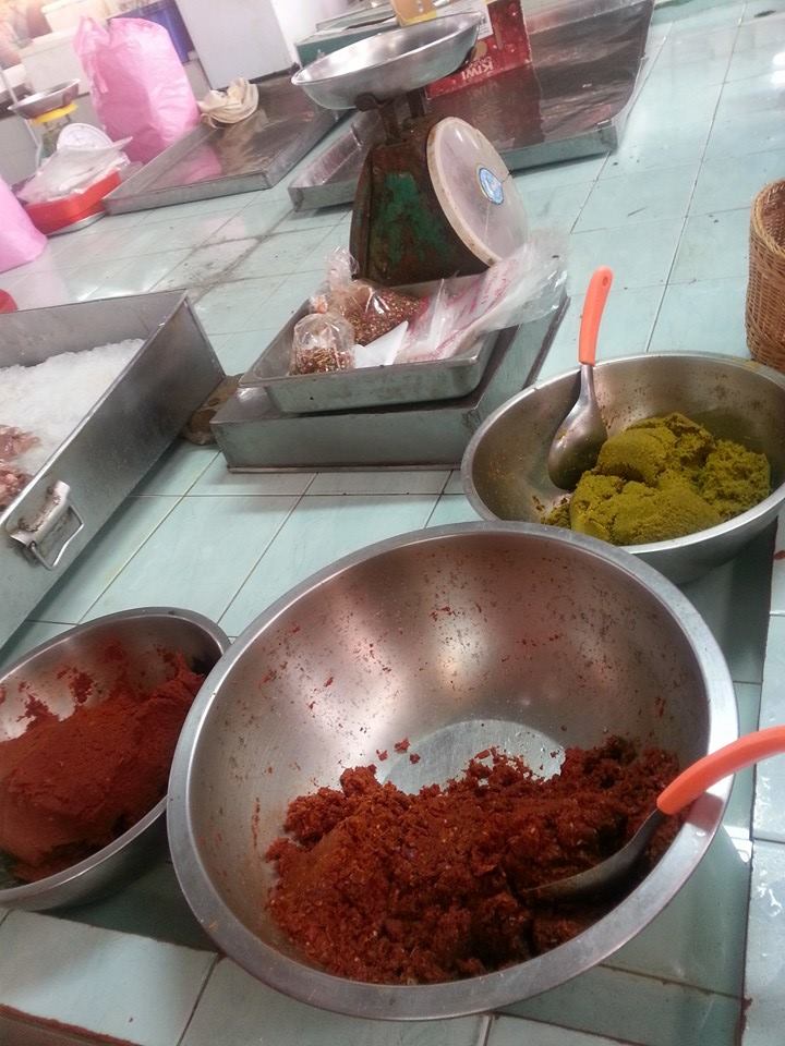 Grounded red, panang and green curry pastes at local market 